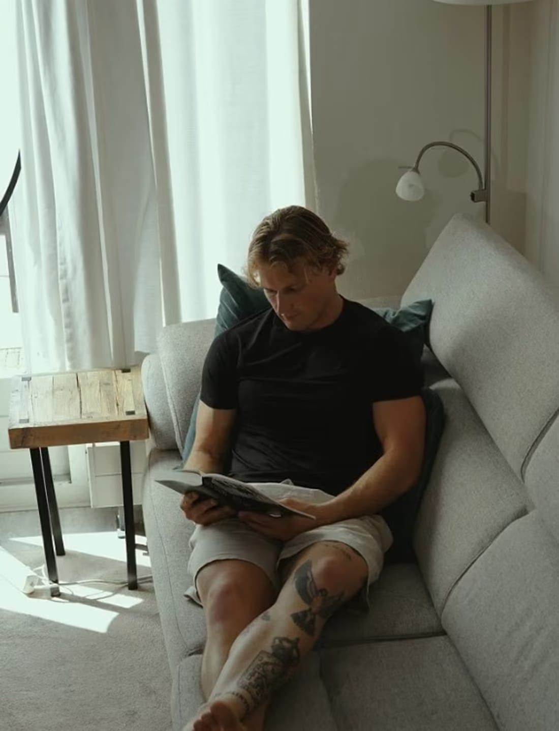 Guus Jacobs leest thuis op de bank